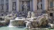 wide view of main structures and sculptures of the Fountain of Trevi with the water cascading down to the pool at the bottom of the Fountain of Trevi