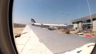 GoPro photograph from inside an airplane at a gate at of Leonardo Da Vinci looking out over the wing towards another airplane at another gate at the airport.