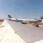 GoPro photograph from inside an airplane at a gate at of Leonardo Da Vinci looking out over the wing towards another airplane at another gate at the airport.