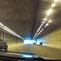 The photograph is a view through the windsheild the GoPro Hero 4 Black camera is mounts to with the GoPro suction cup, outward of the highway with some other cars going through a tunnel in Montreal.