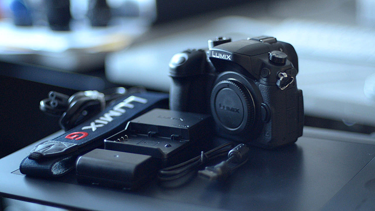 The Photograph shows the Panasonic Lumix GH4 camera body and the accessories that come with the Panasonic GH4 camera.