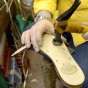 Shoe Maker in Sorrento Italy hammering a strap to the soul of a pair of Custom hand made Italian leather sandals