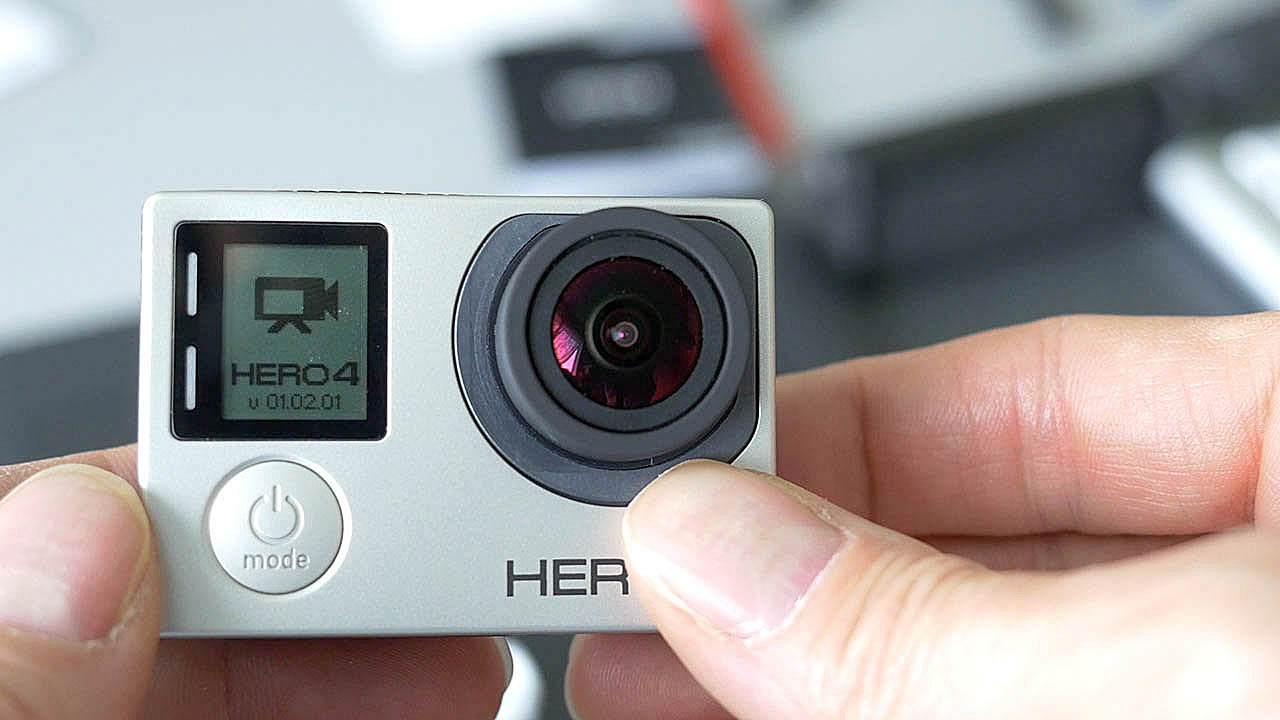 The photograph is a close up of the GoPro Hero 4 Black Edition ifrom straight on with the Hero 4 logo very prominent on the front of the GoPro Hero 4 Black both under the lens and on the lcd screen above the power and mode button